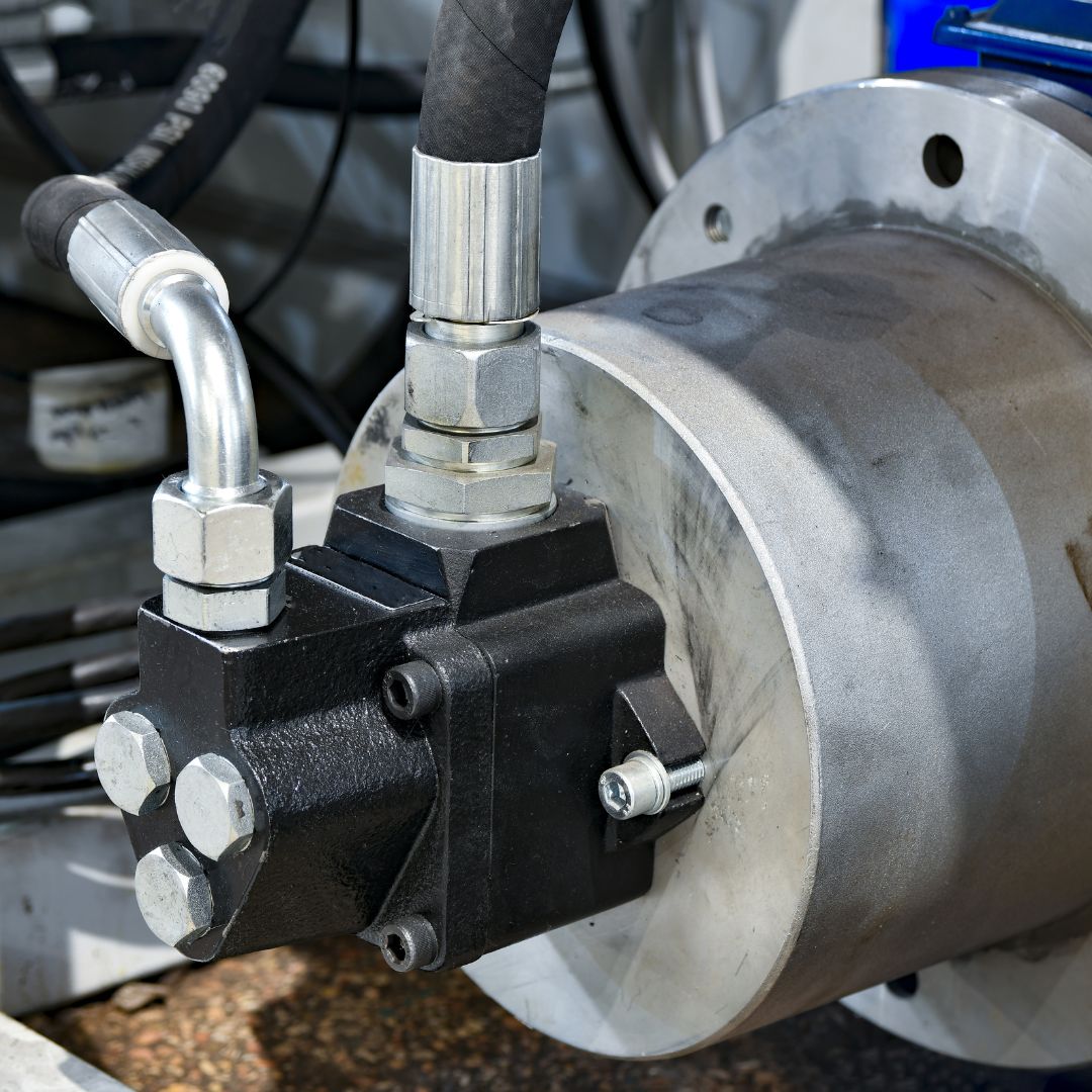 Detalhe de uma bomba hidráulica industrial de alta pressão acoplada a um motor, com tubulação rígida e conexões metálicas. Ilustra a linha de oleohidráulica da Master Hidráulica.